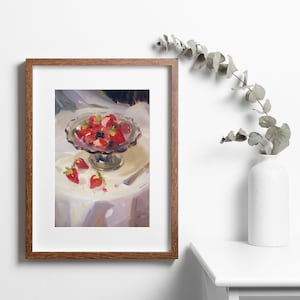 May include: A framed painting of a still life featuring a glass bowl filled with red strawberries and a few strawberries scattered on a white tablecloth.