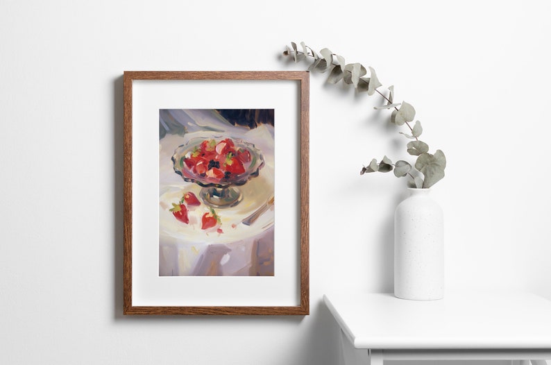 May include: A framed painting of a still life featuring a glass bowl filled with red strawberries and a few strawberries scattered on a white tablecloth.