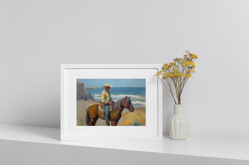 Pu&ograve; includere: Opera d'arte incorniciata raffigurante un cowboy a cavallo sulla spiaggia. Il dipinto mostra un uomo con cappello da cowboy e camicia gialla, che cavalca un cavallo marrone. L'oceano e le scogliere sullo sfondo. Un vaso di fiori gialli a destra.