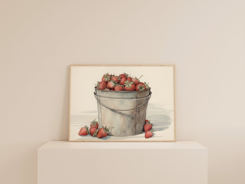 May include: A watercolor painting of a metal bucket filled with red strawberries. The bucket is sitting on a white surface with a few strawberries scattered around it.