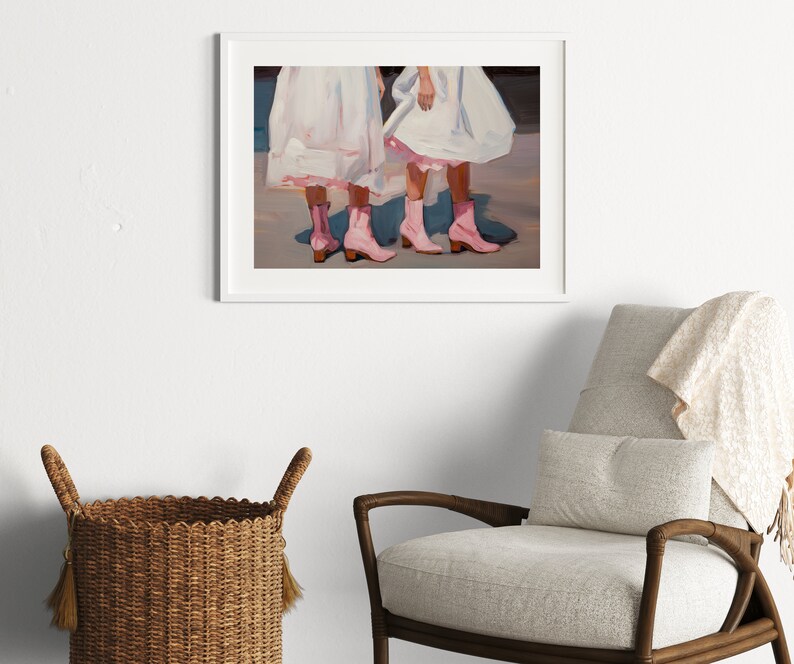 May include: Painting of two people wearing white dresses and pink cowboy boots. The painting is framed in a white frame.
