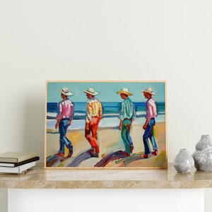 May include: A framed painting depicts four figures in hats and colorful shirts walking on a beach. The figures are painted in a vibrant style, with the ocean and sky in the background. The painting is displayed on a marble surface.