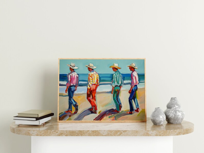 May include: A framed painting depicts four figures in hats and colorful shirts walking on a beach. The figures are painted in a vibrant style, with the ocean and sky in the background. The painting is displayed on a marble surface.