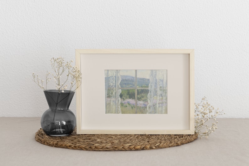 Peut inclure: Une impression encadr&eacute;e d'une sc&egrave;ne de paysage vue &agrave; travers une fen&ecirc;tre avec des rideaux en dentelle blanche. La sc&egrave;ne pr&eacute;sente un champ de fleurs violettes et une colline verdoyante au loin.