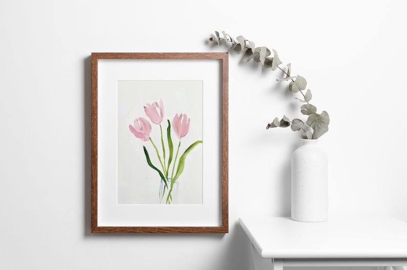 May include: A framed watercolor painting of pink tulips in a clear vase. The painting is set against a white background.