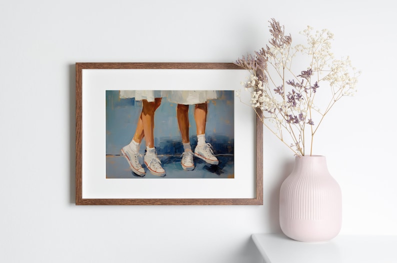 May include: A framed painting depicting two pairs of legs wearing white trainers. The legs are set against a blue background.