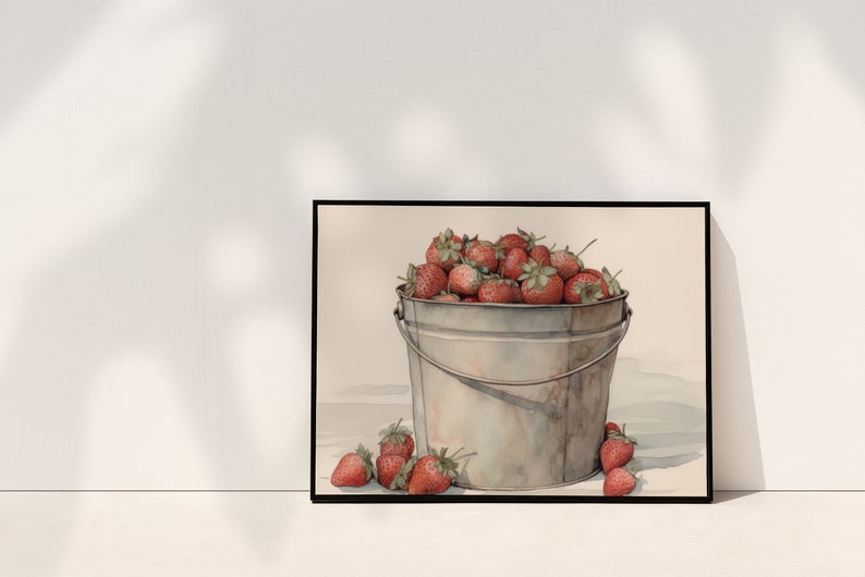 May include: A watercolor painting of a metal bucket filled with red strawberries. The bucket is sitting on a white surface with a few strawberries scattered around it.