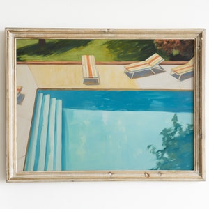 Puede incluir: Una pintura enmarcada de una piscina con tres tumbonas en el borde. La piscina es azul y las tumbonas son blancas con rayas naranjas y rojas. La pintura está sobre un fondo blanco.