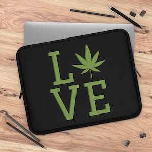 May include: Black laptop sleeve with a green marijuana leaf and the word "LOVE" in green letters.