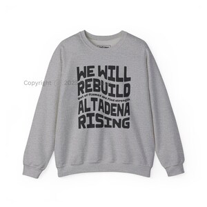 以下が含まれることがあります： 「We Will Rebuild. Out of flames we find strength. Altadena Rising.」という文字が書かれたグレーのスウェットシャツ