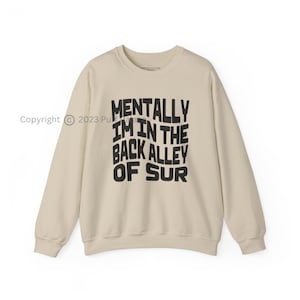 May include: A beige sweatshirt with black text that reads "Mentally I'm in the back alley of sur"