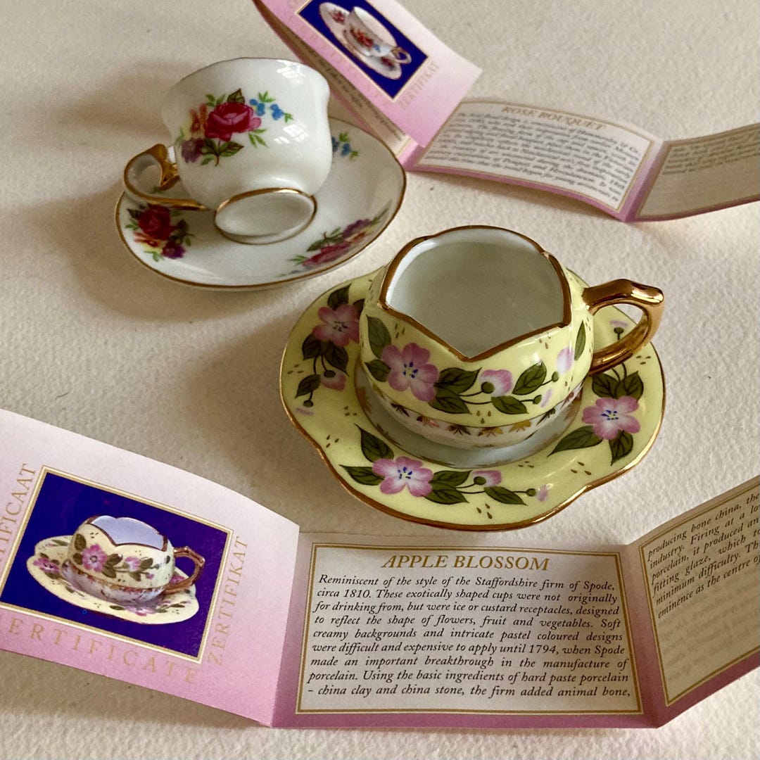Two Miniature Tea Cups and Saucers With Leaflets Describing the