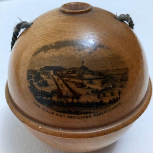 Puede incluir: Una bola de madera con una imagen en blanco y negro de un edificio y el texto "Sea Hills and Pavilions, Mablethorpe".