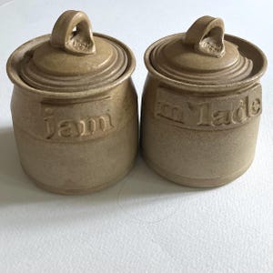 Stoneware studio pottery lidded jam jar and marmalade jar.
