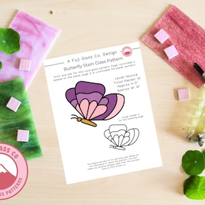 May include: A printable stained glass pattern for a butterfly with purple, pink, and gold accents. The pattern is labeled "Butterfly Stain Glass Pattern" and includes the text "Level: Novice, Total Pieces: 10, Approx H: 5", and "Approx W: 6".