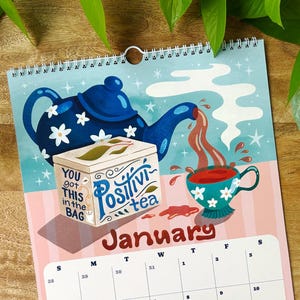 May include: A calendar with a blue teapot design, pouring tea into a teacup. The calendar reads "Positivi-tea" and "January". The text "You got this in the bag" is also visible. The calendar is spiral-bound.