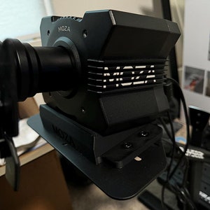 Puede incluir: Un estabilizador de cámara Moza negro con una base negra y el logotipo de Moza en el lateral. El estabilizador está montado en un trípode.