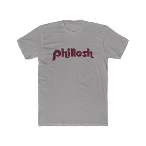 May include: A gray t-shirt with a maroon "philleesh" logo in a retro font.