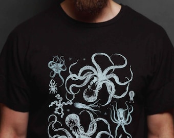 May include: A black short-sleeved t-shirt featuring a detailed, light blue graphic print of various marine creatures, including two large octopuses, a starfish, and other sea life arranged in a cluster across the center of the chest area.