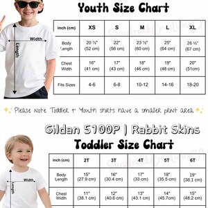May include: A size chart for Gildan 5000B youth and Gildan 5100P Rabbit Skins toddler t-shirts. The chart displays body length, chest width, and sleeve length measurements in inches and centimetres for sizes XS-XL and 2T-6T respectively.