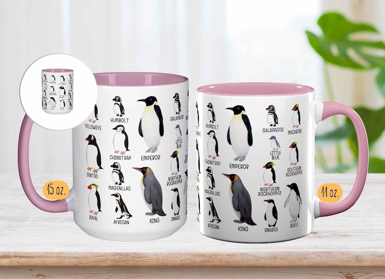 May include: White ceramic mug with a pink interior and handle, featuring illustrations of various penguin species with their names. The mug is labeled "15 oz." and "11 oz."