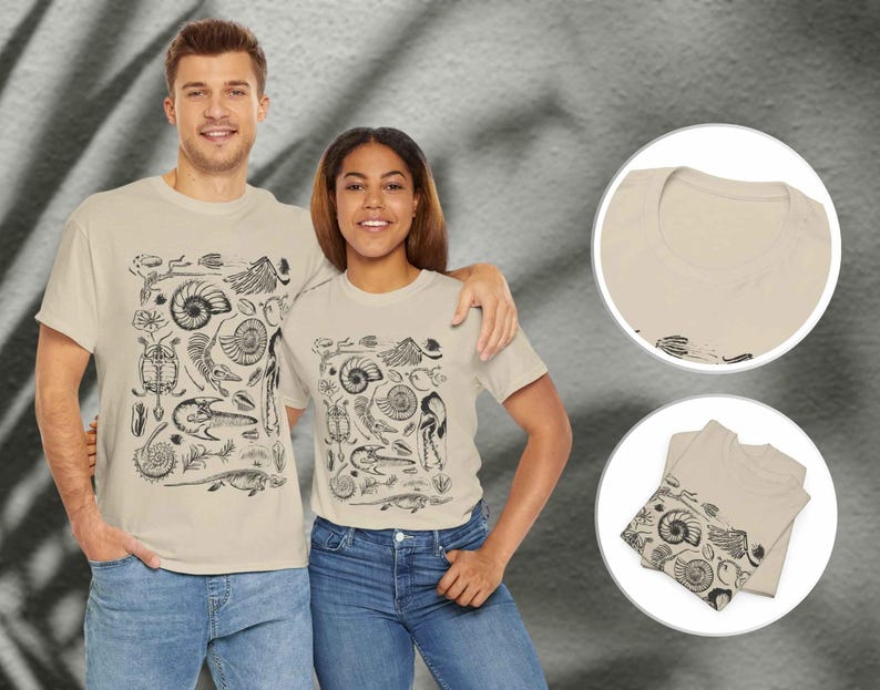 May include: A beige short-sleeve t-shirt featuring a black graphic print of various prehistoric fossils, including ammonites, a turtle, and skeletal remains. The design is centered on the front of the shirt, which has a crew neckline and a standard fit.