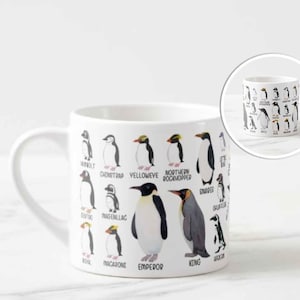 May include: White ceramic mug featuring illustrations of various penguin species, each labeled with its name. The mug includes a handle and a smaller inset image of the mug. The penguin illustrations are in black, white, and yellow.