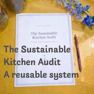 May include: A white document titled The Sustainable Kitchen Audit: A 30-Day Guide to Regenerative Rhythms, featuring a small sprout illustration. A dark brown pen rests on the right side of the paper, which is placed on a yellow surface.