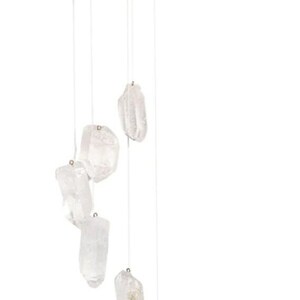 May include: A crystal wind chime with a wooden top and six clear quartz crystals hanging from it.