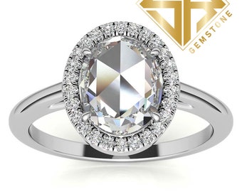 May include: A silver ring with a large oval-shaped diamond set in a halo of smaller diamonds.