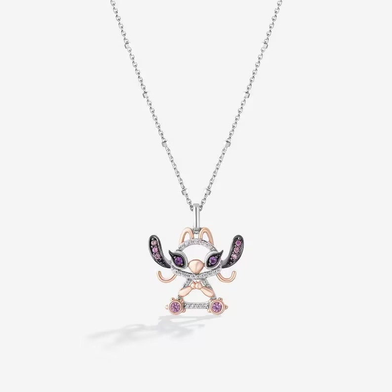 May include: A silver chain necklace with a pendant featuring a cartoon Stitch character. The pendant is made of silver and rose gold and is decorated with purple and pink gemstones.