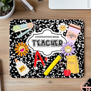 Op de afbeelding: Zwart en wit muismat met een compositieboek-thema met het woord "TEACHER" in een witte lijst. De muismat heeft schoolgerelateerde afbeeldingen zoals een nietmachine, lijm, een liniaal en een koffiekopje. Er is een rode appel en een lunchzak.