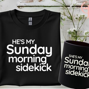 May include: Black t-shirt with white text that reads "He's my Sunday morning sidekick". A black mug with white text that reads "She's my Sunday morning sidekick".