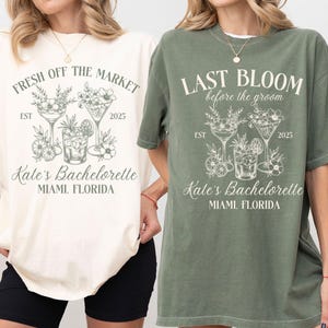 May include: Two women's t-shirts with a bachelorette party theme. The ivory shirt says "Fresh Off The Market" and the green shirt says "Last Bloom Before The Groom". Both shirts feature a graphic of three cocktails with floral accents and the text "Kate's Bachelorette Miami, Florida".