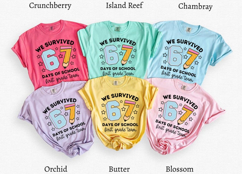 May include: A collection of six short-sleeved t-shirts in various colors, including pink, blue, yellow, and purple. Each shirt features the text "WE SURVIVED 67 DAYS OF SCHOOL first grade team" with a pencil graphic.