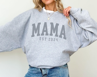 May include: Gray sweatshirt with the text "MAMA EST 2024" in a collegiate font.