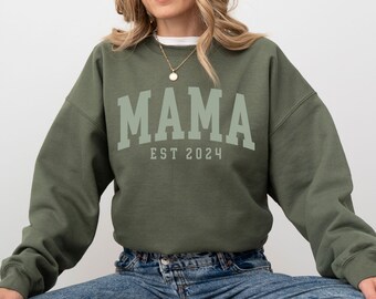 May include: A green sweatshirt with the text "MAMA EST 2024" in white.