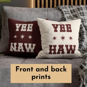 May include: Two decorative throw pillows with a brown background and white text. The front pillow says "Yee Haw" with three white stars. The back pillow says "Yee Naw" with three white stars.