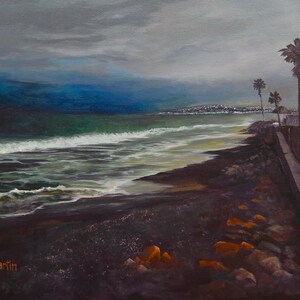 Puede incluir: Pintura al óleo de una escena costera bajo un cielo nublado. Las olas del océano rompen en una costa oscura y rocosa. Se ven palmeras y un edificio a la derecha, con un paisaje urbano distante en el horizonte. La firma del artista está en la parte inferior izquierda.