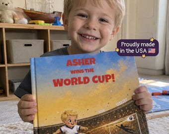 Puede incluir: Un libro infantil de tapa dura titulado Asher Wins the World Cup! de Sue Donhym. La portada presenta una ilustración de dibujos animados de un joven jugador de fútbol en un campo de un estadio, con texto en rojo brillante y una etiqueta.