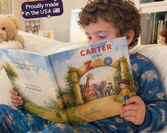Puede incluir: Un libro infantil personalizado titulado Carter at the Zoo de Sue Donhym, con una colorida ilustración de la entrada de un zoológico con una jirafa, un elefante y una cebra. El libro incluye texto que indica que está hecho para Carter.