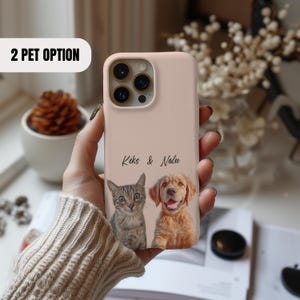 Pu&ograve; includere: Una custodia per telefono rosa con un gatto e un cane. Il testo "Keks & Nalu" &egrave; stampato sulla custodia.