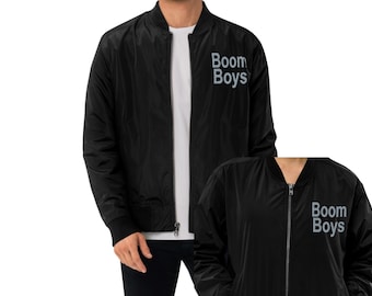 Puede incluir: Chaqueta bomber negra con cierre de cremallera y el texto "Boom Boys" en blanco en la parte delantera.