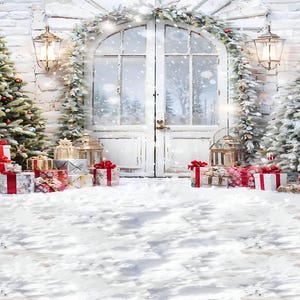 Pode incluir: Uma cena de inverno nevada com duas árvores de Natal decoradas, uma porta branca e presentes embrulhados em papel vermelho e branco. A cena se passa contra uma parede de tijolos brancos com uma guirlanda de vegetação e luzes.