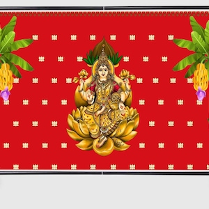 Pode incluir: Um banner de fundo vermelho montado num suporte de metal preto com uma ilustração central de uma divindade sentada numa flor de lótus dourada, ladeada por duas bananeiras com frutos amarelos e um padrão repetitivo de pequenos lótus brancos.