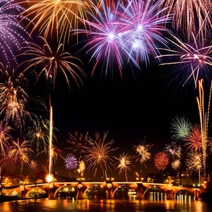 Pode incluir: Um céu noturno cheio de fogos de artifício coloridos que explodem sobre uma ponte. Os fogos de artifício são vermelhos, laranja, amarelos, verdes, azuis e roxos. A ponte está iluminada com luzes.