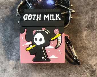 Puede incluir: Una funda de silicona rosa y negra para auriculares inalámbricos, con una caricatura de la Muerte sosteniendo una guadaña. La funda tiene una parte superior negra con el texto "GOTH MILK" en blanco.