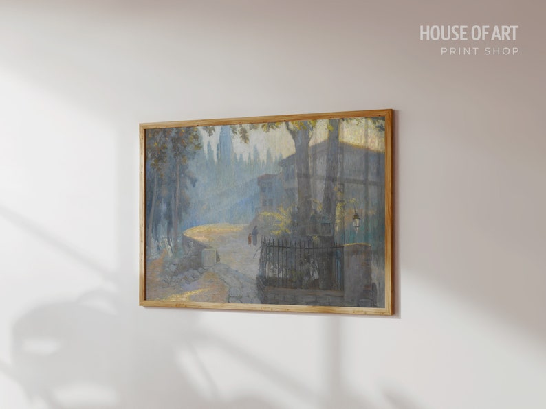 May include: A framed painting depicting a street scene with buildings, trees, and figures in a hazy, atmospheric style. The painting is in a light blue and gray color palette.