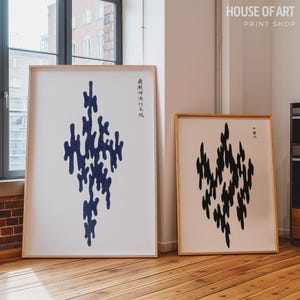 Puede incluir: Dos impresiones artísticas abstractas enmarcadas. Una presenta una forma orgánica azul sobre fondo blanco, la otra una forma negra. Ambas están en marcos de madera clara. Las impresiones se exhiben en una habitación con suelo de madera.