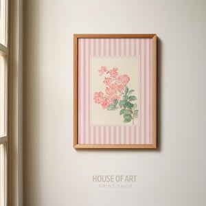 May include: A framed floral print featuring pink flowers and green leaves. The artwork is set against a pink and white striped background, encased in a wooden frame. The text "HOUSE OF ART PRINT SHOP" is at the bottom.